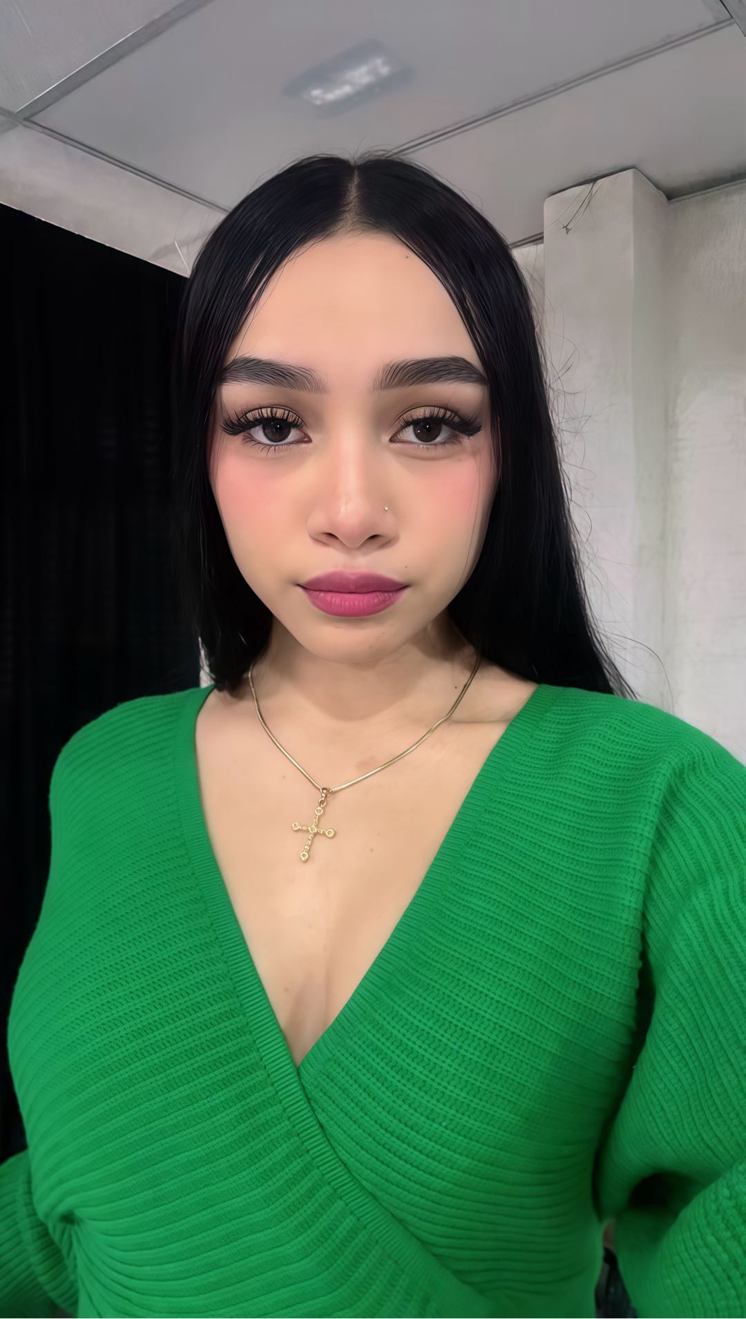 Woman with dark hair and a green top looking into the camera