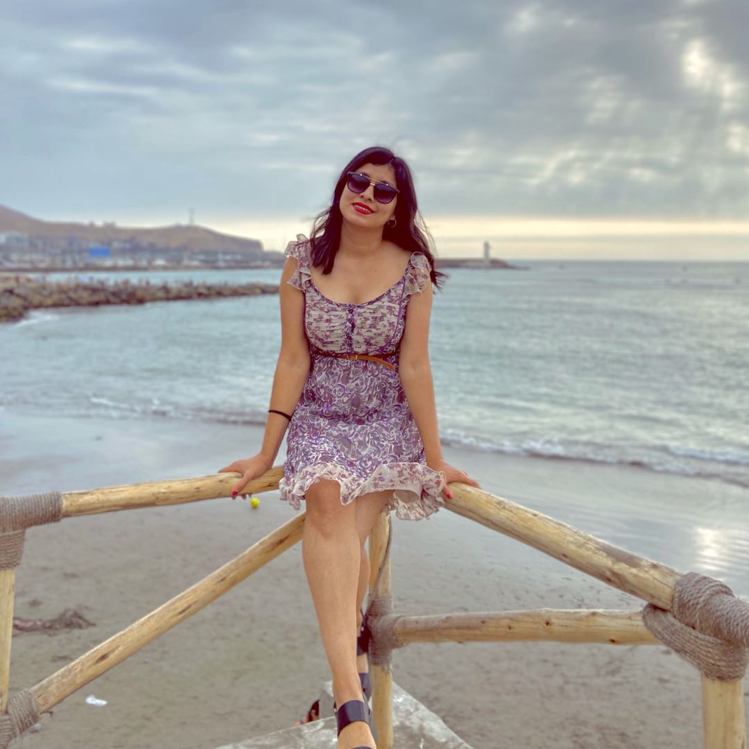 A woman in a patterned dress beside the sea